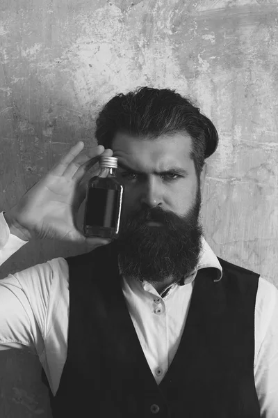 Hipster posing with bottle of red liqueur — Stock Photo, Image