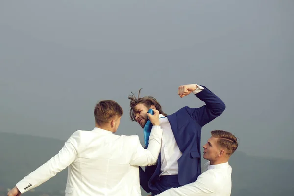 Geschäftsmann schlägt auf Kollegen ein, zwei Männer in festlichem Outfit — Stockfoto