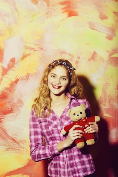 Feliz chica bonita sonríe con lindo oso de peluche en rojo —  Fotos de Stock