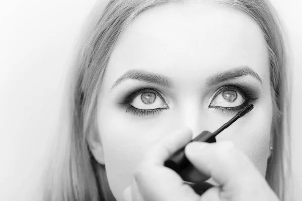 Borsta i hand tillämpa svart mascara på flicka ögonfransar — Stockfoto