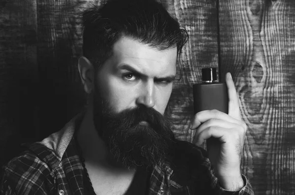 Hipster posando com perfume preto ou garrafa de colônia — Fotografia de Stock