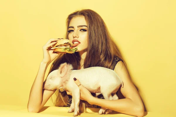 돼지와 함께 햄버거를 먹는 여자 — 스톡 사진