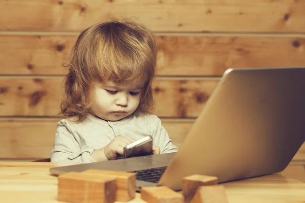 Menino pequeno com computador e telefone — Fotografia de Stock