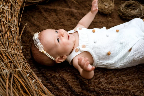 Newborn baby happy smiling in wicker crib. Newborn baby girl. Early childhood. A happy childhood lasts a lifetime. Happy care with personal touch