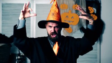 Sakallı sihirbaz ellerini dalgalar ve Cadılar Bayramı büyü okur. Cadılar Bayramı partisi ve kutlama kavramı. Büyücülük Halloween kavramı.