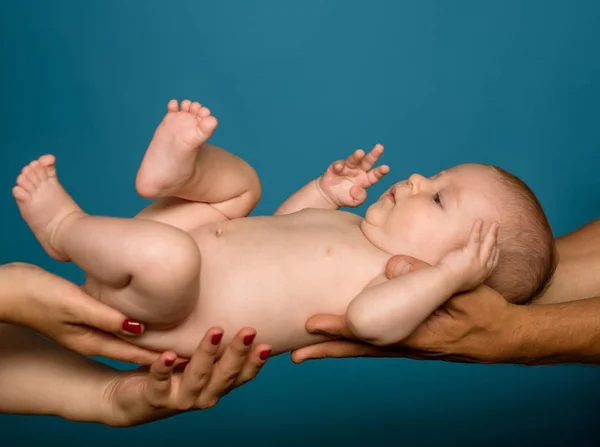 Νεογέννητο μωρό στα χέρια των ενοίκων τους γονείς. Νεογέννητο μωρό ξύπνιο σε ύπτια θέση. Εμβρυϊκή ανάπτυξη και την ανάπτυξη. Φροντίδα του εμβρύου. Τα χέρια που φροντίδα. Το καλύτερο για την ανάπτυξη του παιδιού — Φωτογραφία Αρχείου