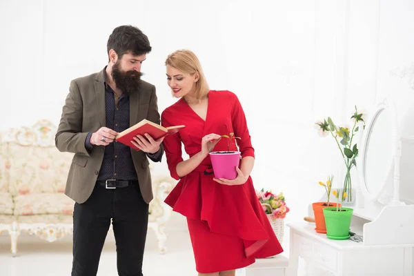 Knowledge concept. Bearded man read book about growing plants to woman, knowledge. Gardening knowledge library. Knowledge is a seed that grows when you read.