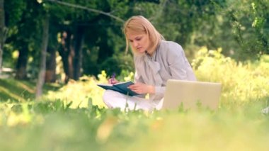 Parkta çim üzerinde oturan bir defter bir kadın yazar. Bir öğrenci çimenlerin üzerinde bir parkta otururken sınavlarına hazırlanıyor.