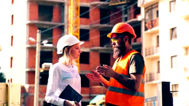 The construction manager communicates with the builder at the construction site. Concept of heavy construction. — Stock Video