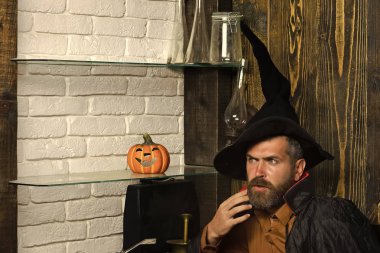 Cadılar Bayramı adam Sihirbazı balkabağı ile kara cadı şapka oturmuş