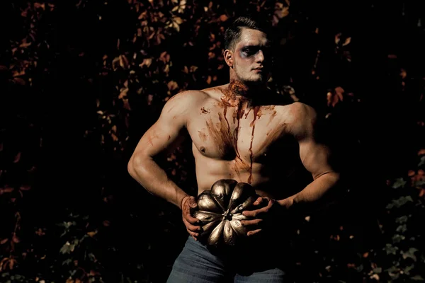 ハロウィーン男ゾンビ顔、筋肉のついた体保持カボチャ — ストック写真