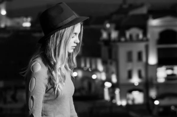 Το κορίτσι με το καπέλο στο προφίλ, φόντο πόλη νύχτα — Φωτογραφία Αρχείου