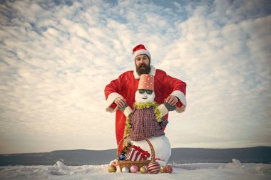 Adam Noel Baba şapkası karlı heykel ile elele