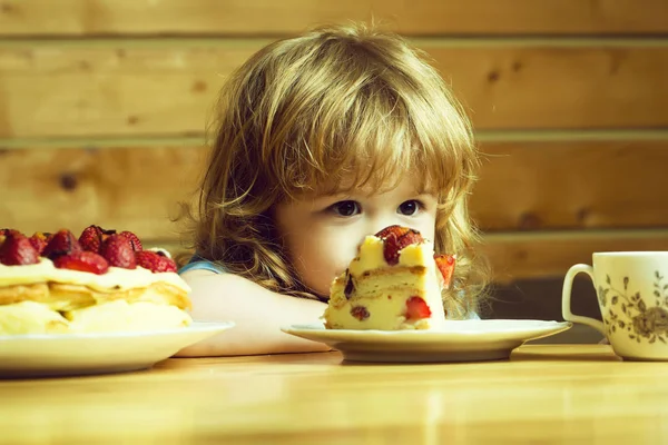 Kleine jongen eet aardbeien cake — Stockfoto