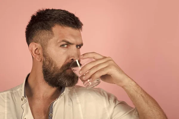 Людина з бородою на обличчі п'є воду зі скла — стокове фото