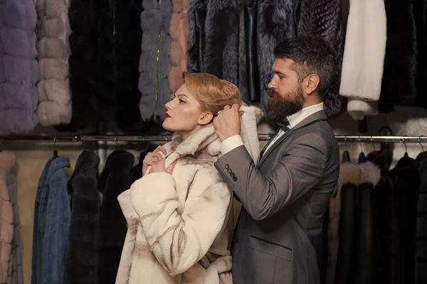 Customer with beard and woman buy furry coat.