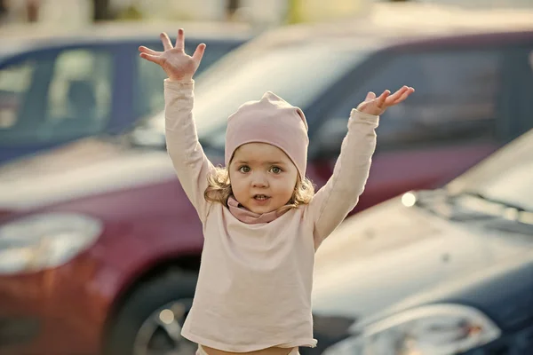Chica con las manos levantadas de pie en el aparcamiento — Foto de Stock