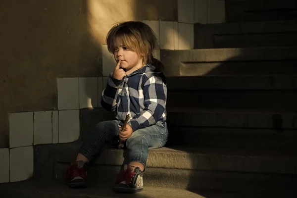 Chłopiec z myślenia twarzy siedzieć na schodach domu — Zdjęcie stockowe