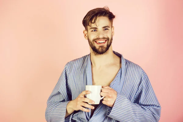 Муж мужчина пьет чашку чая или кофе в халате — стоковое фото