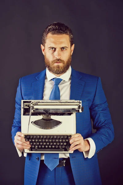 man with typewriter in fashion blue business suit on grey background