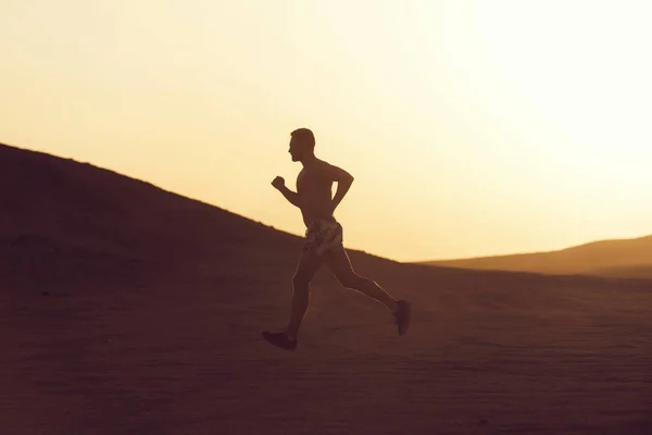 Muž běžec běží v Duně při západu slunce — Stock fotografie