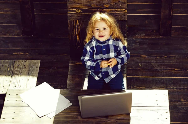 Heureux petit garçon travail à l'ordinateur avec feuille de papier — Photo