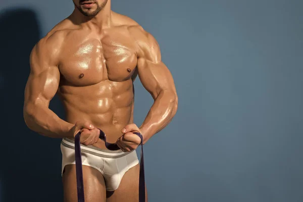 Man with muscular wet body and torso hold rubber. — Stock Photo, Image