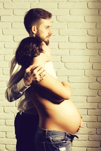 Бородатый мужчина и красивая беременная женщина с обнаженным круглым животом — стоковое фото