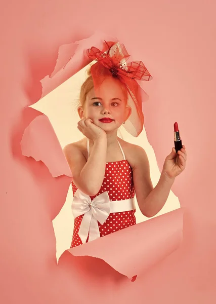 小さな女の子保留口紅。ピンクの背景の女の子 — ストック写真