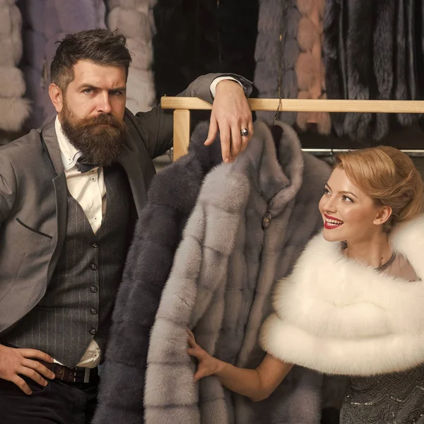 man and woman among fur coat.