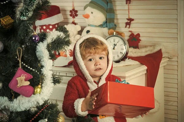 Christmas child or small boy in santa coat hold present — Stock Photo, Image