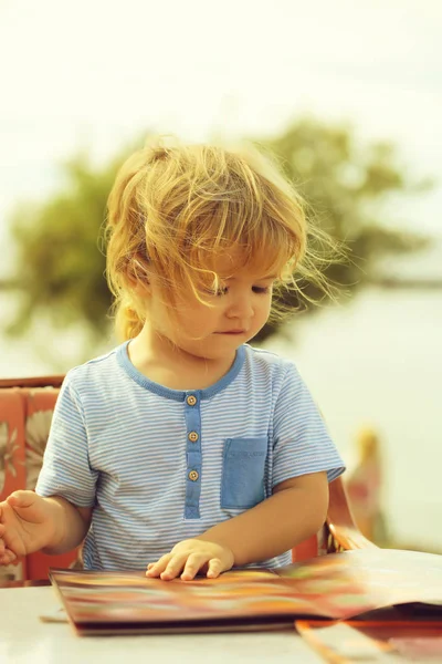 Niedlicher kleiner Junge liest Speisekarte — Stockfoto
