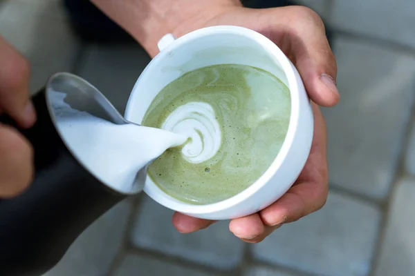 Entspannen Sie sich im Café oder Café und trinken Sie. Barista gießen Milch in japanischen Teegetränk. Matcha Latte Teezeremonie, Milch aufgießen. perfekten Morgen mit grünem Kaffee. Warm werden mit heißem Kaffee — Stockfoto