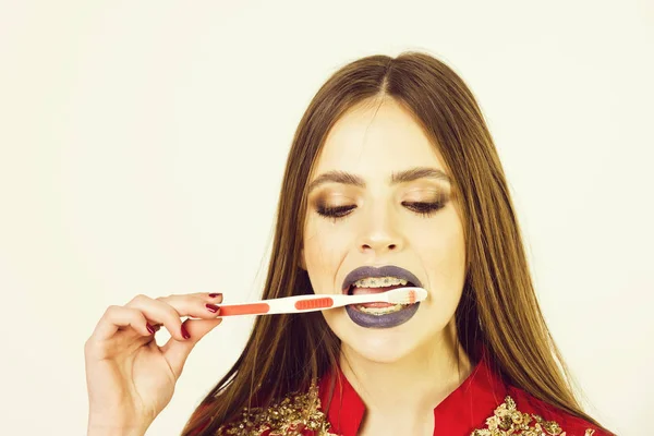 Flicka med tänder hängslen och borste, har fashionabla makeup — Stockfoto