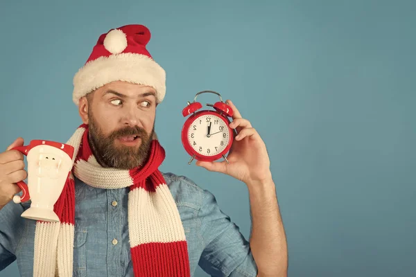 Boże Narodzenie hipster w santa czapkę, szalik zaskoczony na niebieskim tle — Zdjęcie stockowe