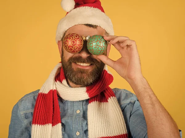 Kerst man cover ogen met xmas ballen op gele achtergrond — Stockfoto