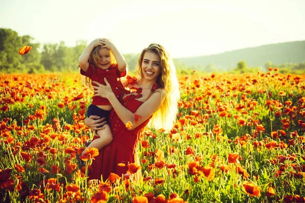 Vrouw en kleine jongen of kind op gebied van papaver — Stockfoto