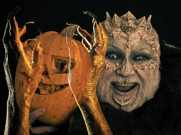 Homem de Halloween com pele de dragão sorrindo com abóbora — Fotografia de Stock