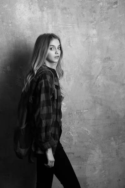 Beautiful girl with backpack in stylish red checkered shirt — Stock Photo, Image