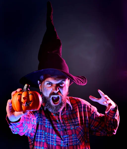 Uomo di Halloween con la faccia spaventosa su sfondo scuro. Halloween, festa delle feste. spaventoso faccia uomo con orrore make up tenendo zucca testa jack lanterna. — Foto Stock