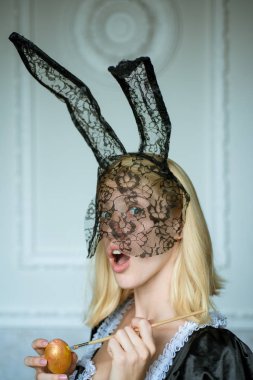 Tavşan kulakları giyen ve renkli bir Easter egg tutan çekici genç kadın. Seksi sarışın kız dantel tavşan kulaklı. Kadın Paskalya.