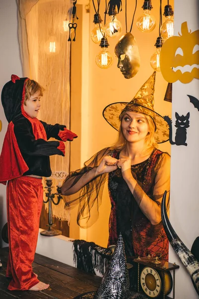 Madre y su hijo juegan juntos. Amor familiar y fiesta de Halloween. Feliz Halloween. Hermosa mujer joven con un niño con calabazas otoño. Sonriente madre e hijo. — Foto de Stock