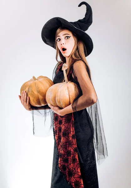 Giovani donne emotive in costumi di Halloween sulla festa su sfondo bianco con zucca. Isolato su sfondo bianco . — Foto Stock