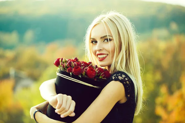 Söt flicka med blommor i rutan — Stockfoto