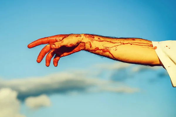 Sangrienta mano zombi con sangre roja en el cielo azul — Foto de Stock