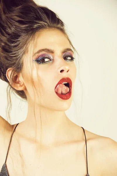 Maquiagem, menina com maquiagem elegante e lábios vermelhos mostrando língua — Fotografia de Stock