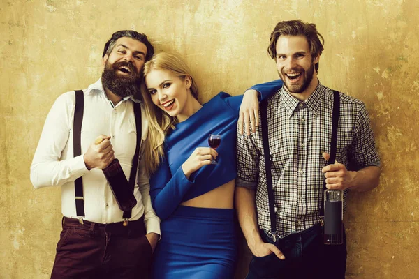 Uomini in possesso di bottiglie di vino e ragazza con bicchiere di liquore — Foto Stock