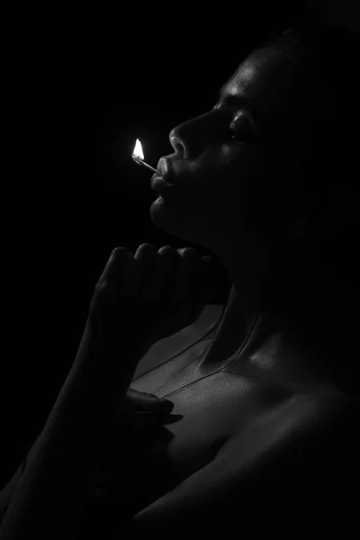 Девушка держит горящую спичку во рту — стоковое фото