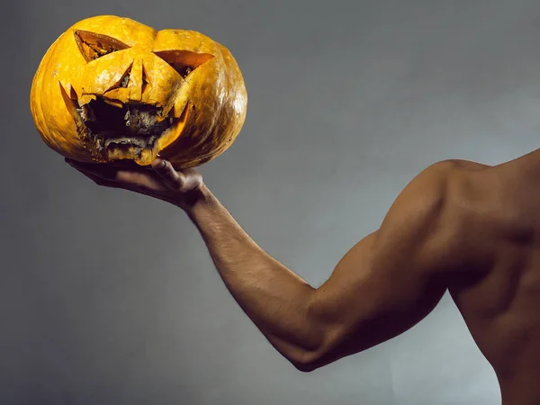 Mano masculina muscular con calabaza — Foto de Stock