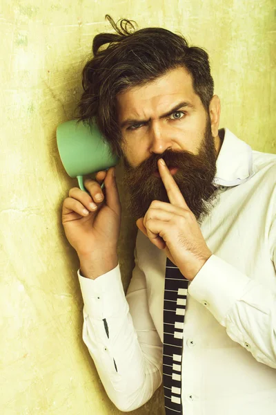 Homem com barba ouvir fofocas com copo . — Fotografia de Stock